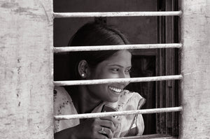 Jeune femme derrière les barreaux d’un wagon de train en Inde