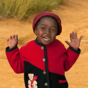 Petit enfant tout sourire après une course. Dans les terre rouges du Centre de Madagascar