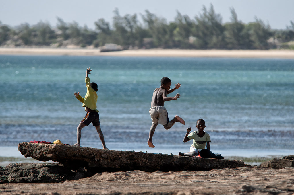 Sur les bords de l'océan, enfants soudain excités, jouant des pieds et de mains