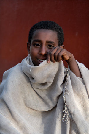 Jeune homme dans le Tigré, en Ethiopie, main découvrant son sourire et ses yeux