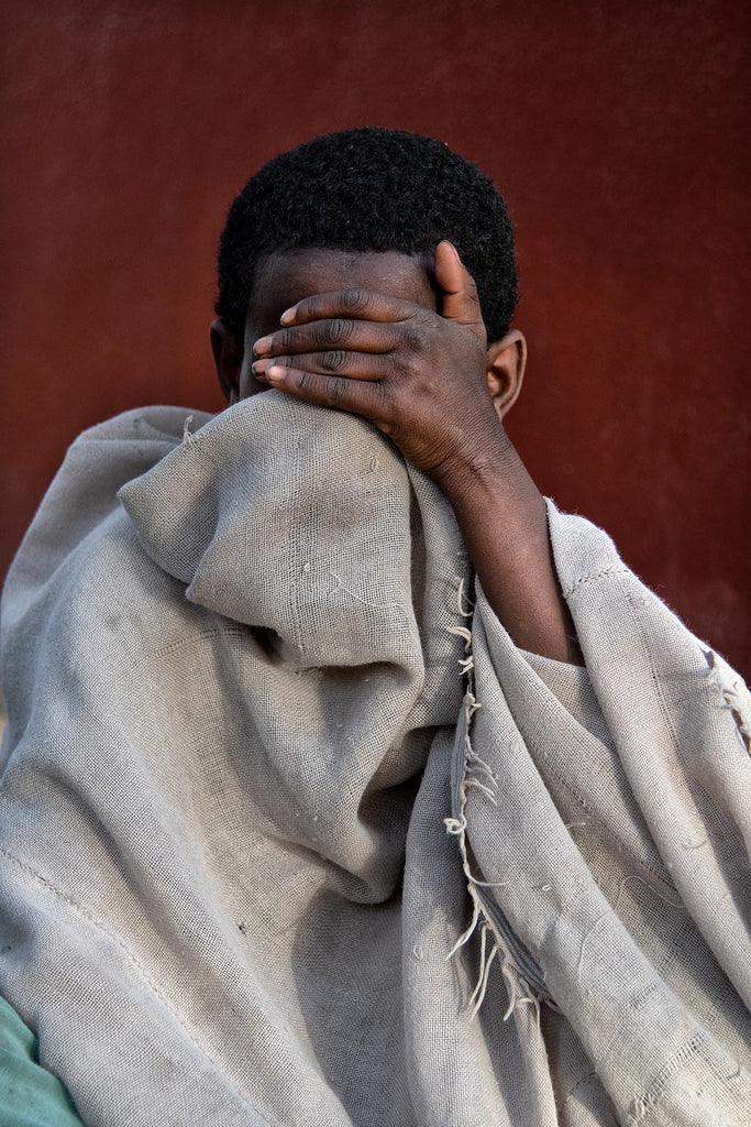 Jeune homme dans le Tigré, en Ethiopie, se cachant le visage - Cache cache ?