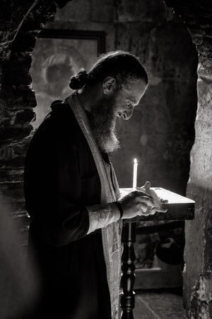 Lumières dans une petite chapelle, sourire discret d'un prêtre orthodoxe de Géorgie
