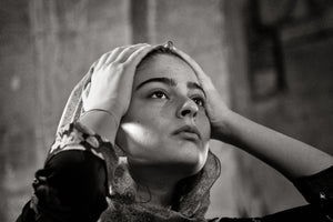 Jeune femme replaçant son voile brodé à l'intérieur d'une église en Géorgie
