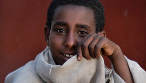 Tendresse d'un sourire qui s'ouvre, lumière des yeux - Jeune homme d'Ethiopie